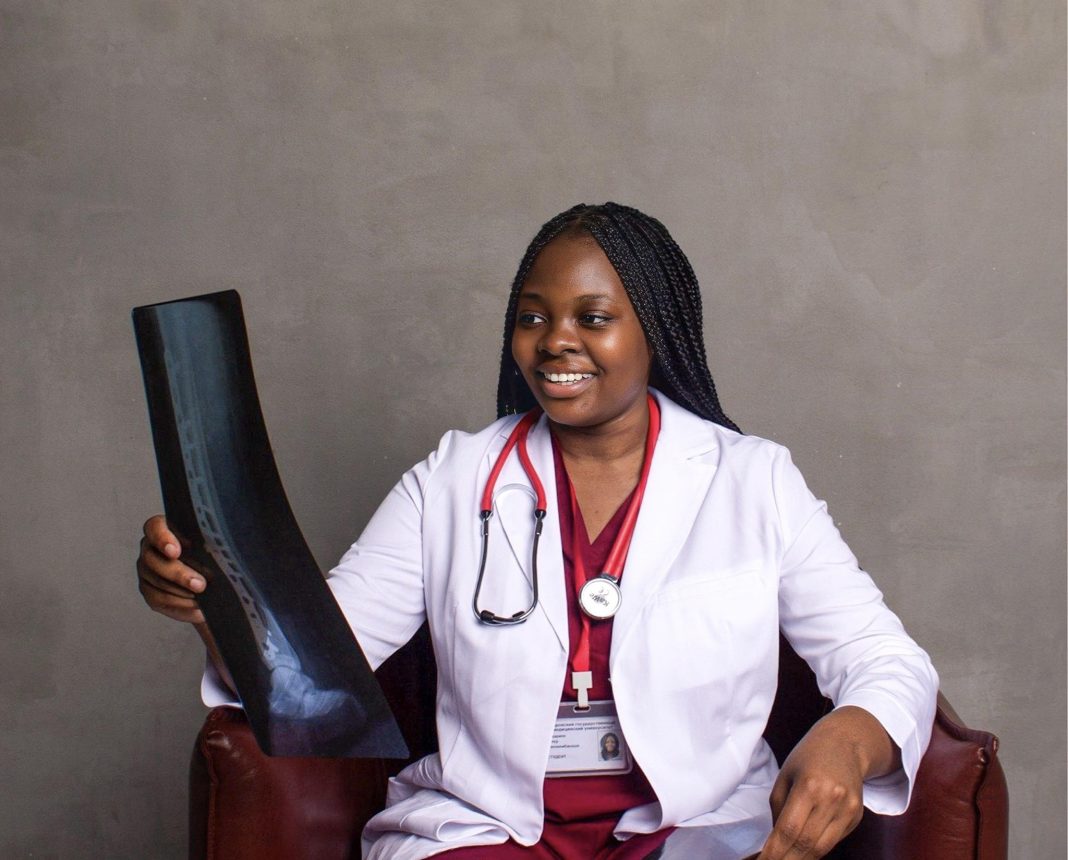 Dr Esther Makaripe, a medical professional, seated and holding an X-ray image