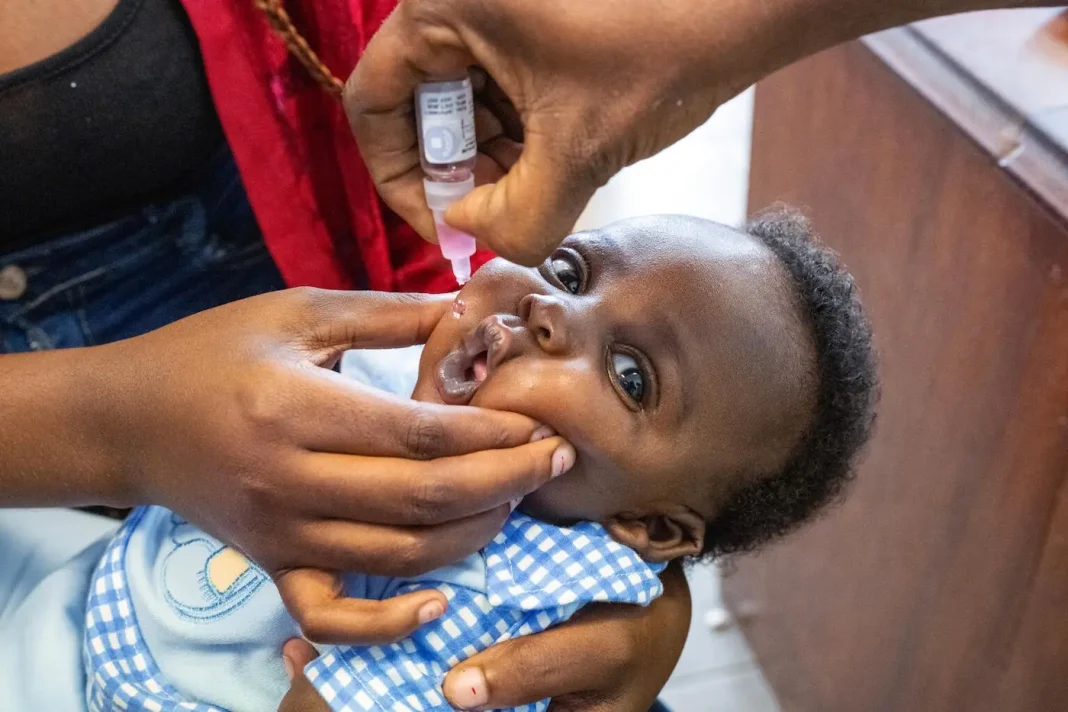 Child receiving oral vaccine drops during routine vaccination