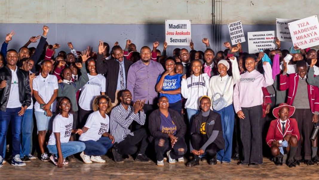 Participants at a boy child campaign event in Zimbabwe pose with placards calling for support and mentorship for boys.