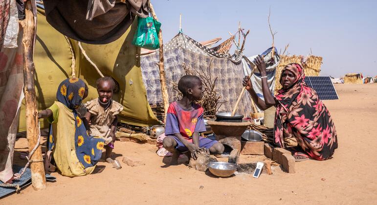 Children sit outside a temporary shelter in Darfur amid hunger, displacement and disease.