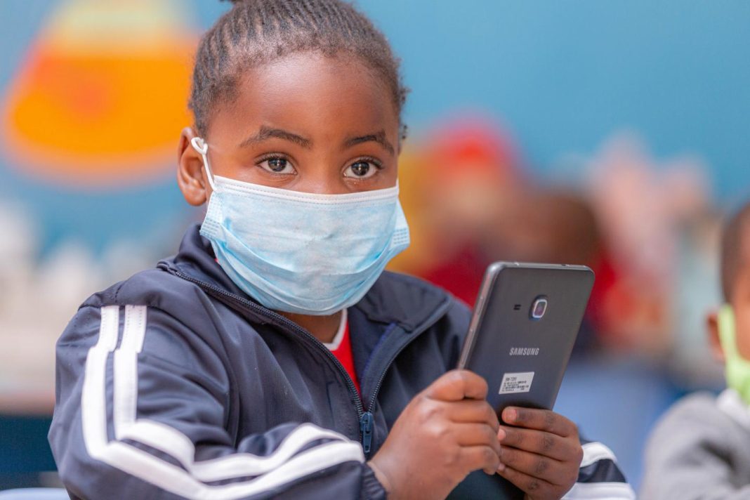 Child holding a mobile phone as Zimbabwe moves to protect children from online abuse.