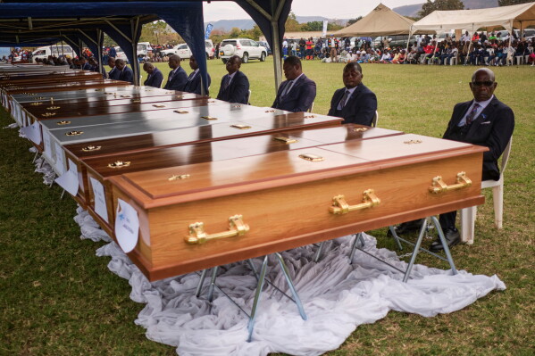 Funeral pallbearers sit behind rows of caskets at the Lake Kariba ferry disaster memorial service in Kariba.