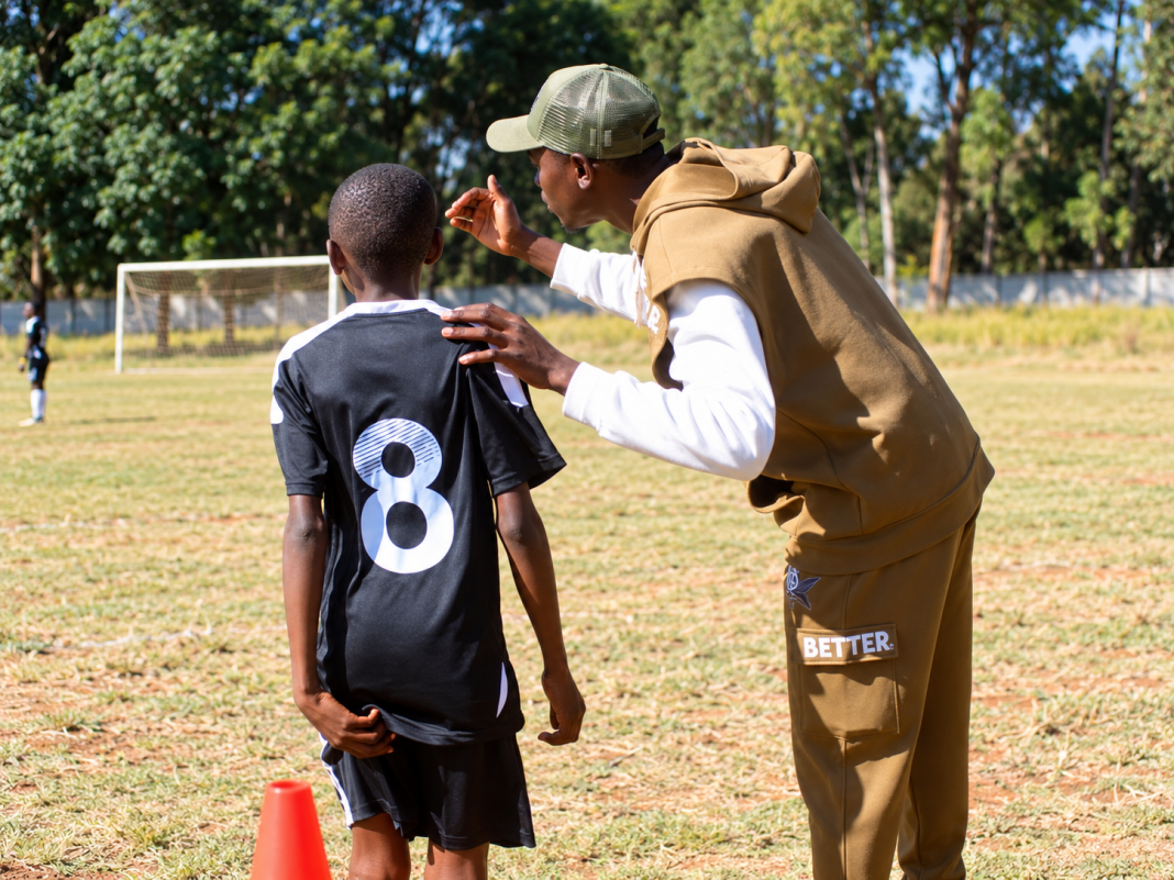 Daniel Chigiya coaching a young footballer during a training session