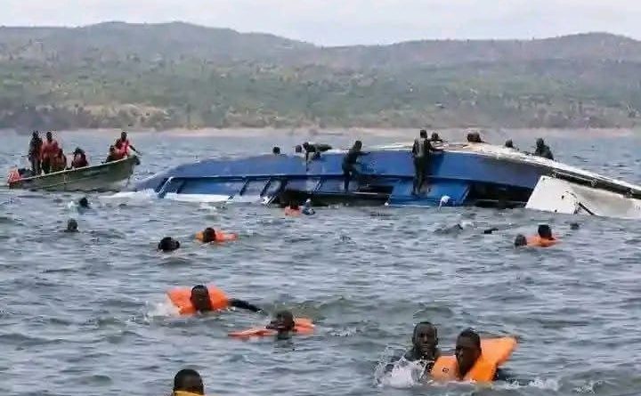 People wearing life jackets beside the overturned Mbuya Nehanda ferry on Lake Kariba
