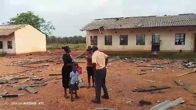 Residents stand among scattered roofing debris outside buildings in Tshitulipasi, Beitbridge, following a hailstorm.